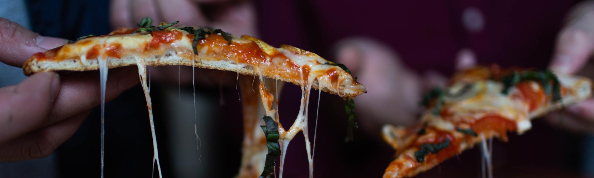 2 slices of pizza with stringing cheese